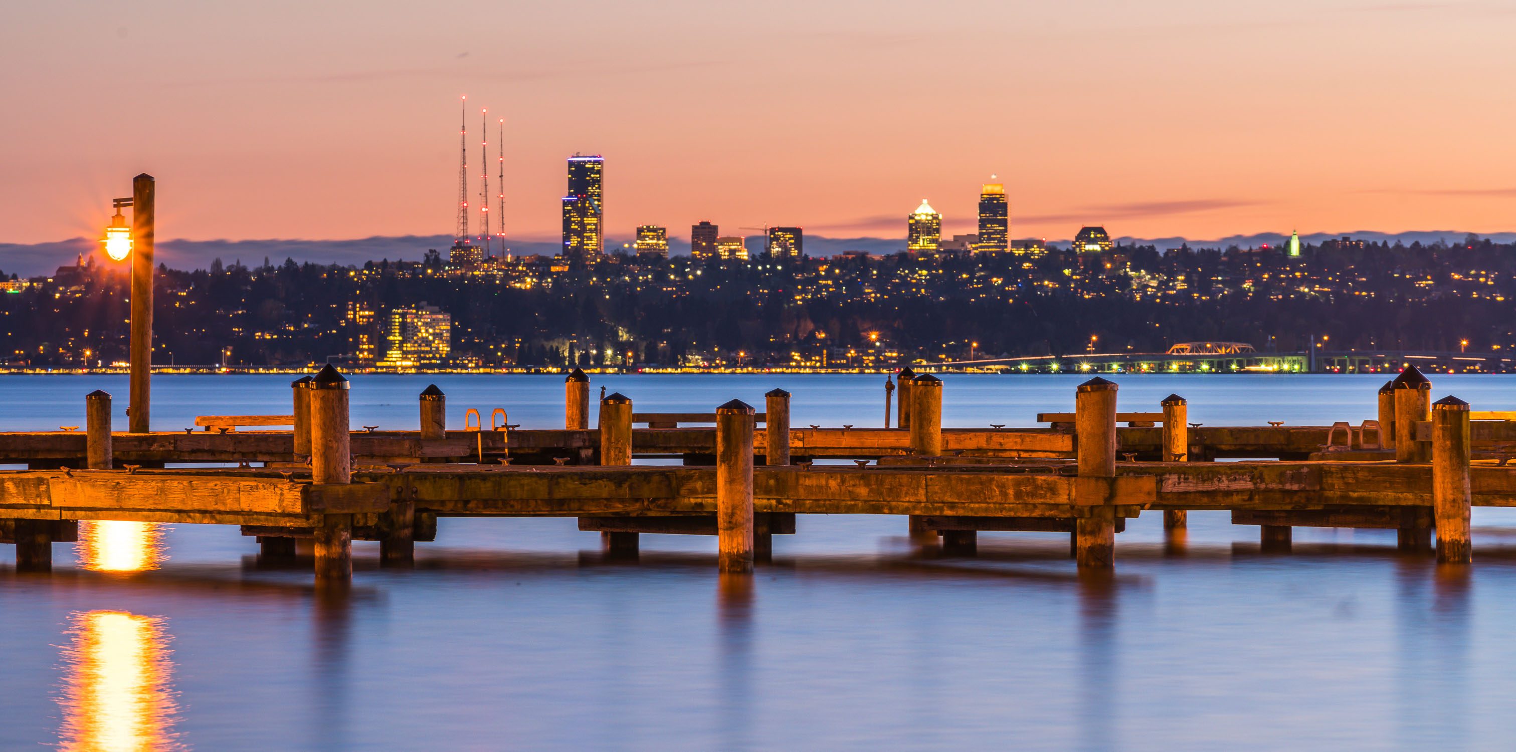 dock with background of Bellevue cityscape with reflection on lake washington at night